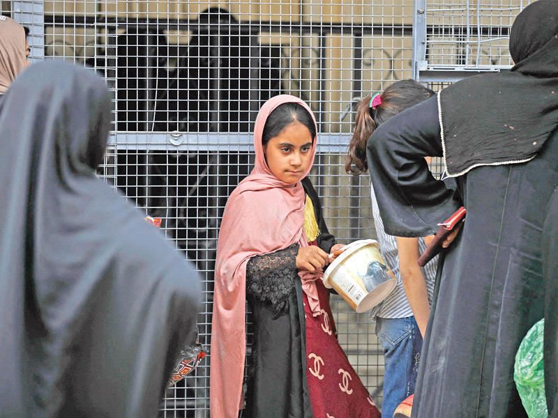 فتاة عراقية تنتظر دورها للحصول على طعام الإفطار في مسجد عبدالقادر الجيلاني ببغداد (أ ف ب) 