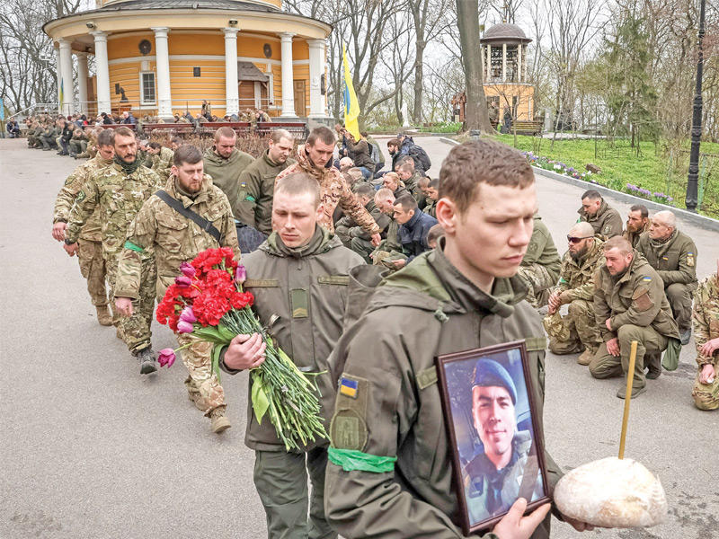 جانب من جنازة أربعة جنود أوكران في كييف أمس قتلوا بمعارك مع الروس  (رويترز)