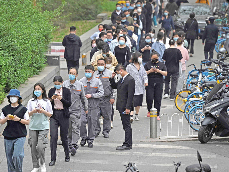 صينيون ينتظرون دورهم لإجراء فحص PCR في بكين أمس (أ ف ب)