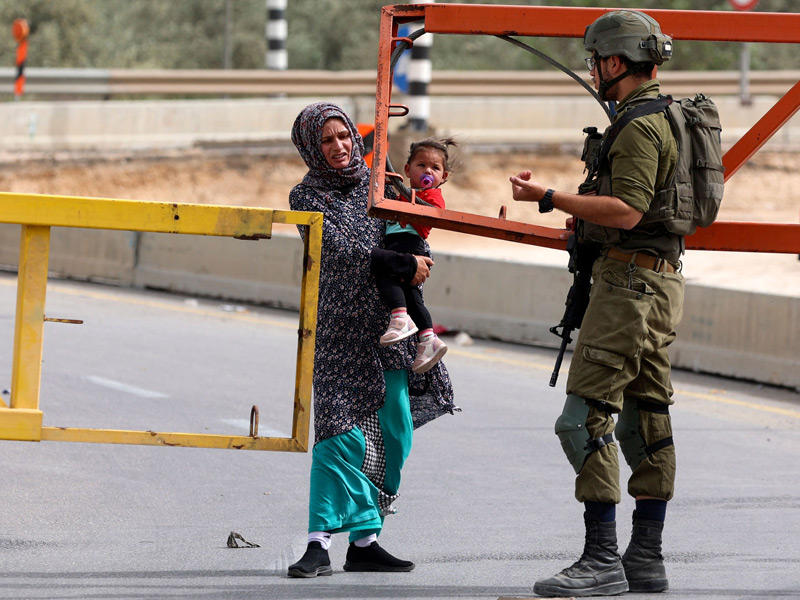 امرأة فلسطينية خلال عبورها على حاجز إسرائيلي في الضفة الغربية المحتلة (أ ف ب)