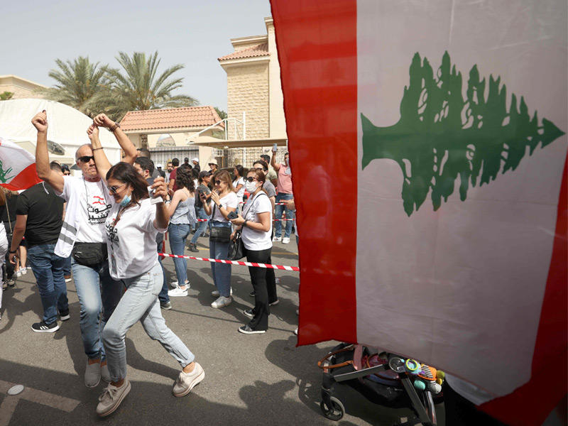 لبنانيون يرقصون بانتظار الاقتراع امام قنصلية بلادهم في دبي (أ ف ب) 