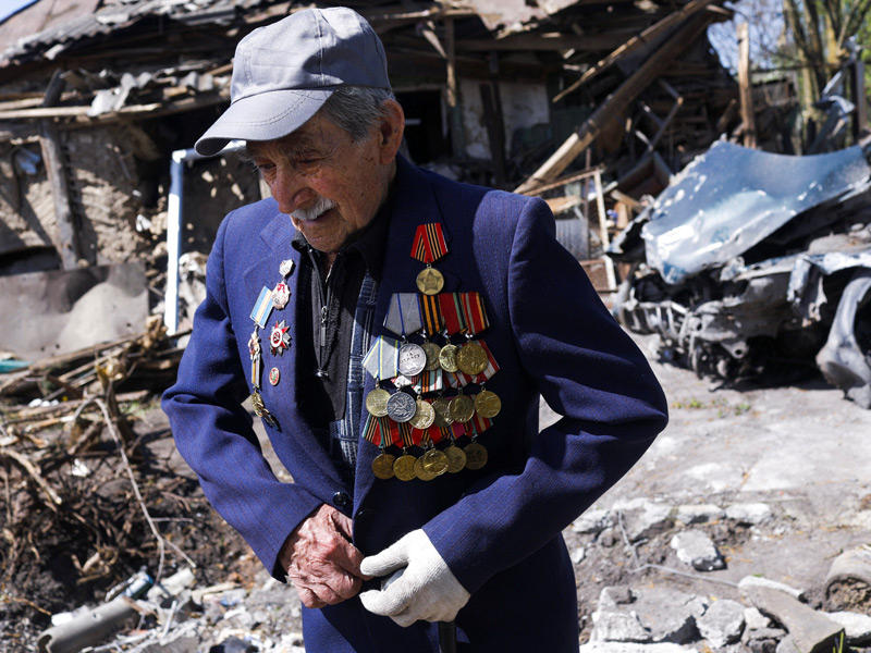 مقاتل أوكراني من الحرب العالمية الثانية يبلغ 97 عاماً أمام منزله المدمر بقصف روسي في زولوشيف (رويترز)