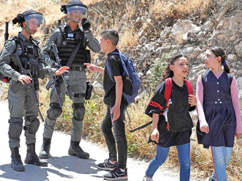 فتى فلسطيني يواجه جنديين إسرائيليين خلال هدم منزل في القدس الشرقية (أ ف ب)