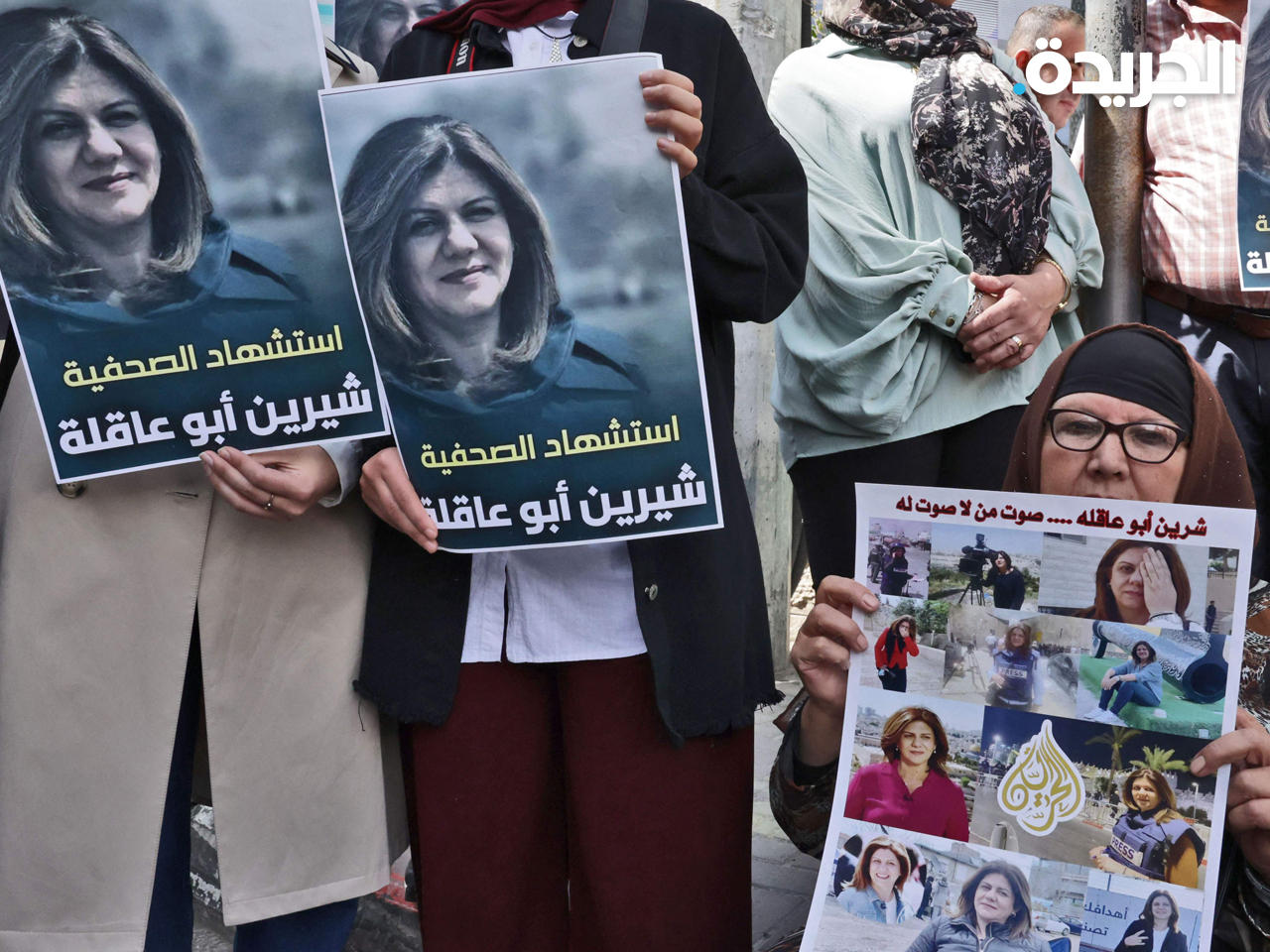 فلسطينيون يحملون ملصقات تظهر شيرين أبو عقلة التي قُتلت برصاص القوات الإسرائيلية