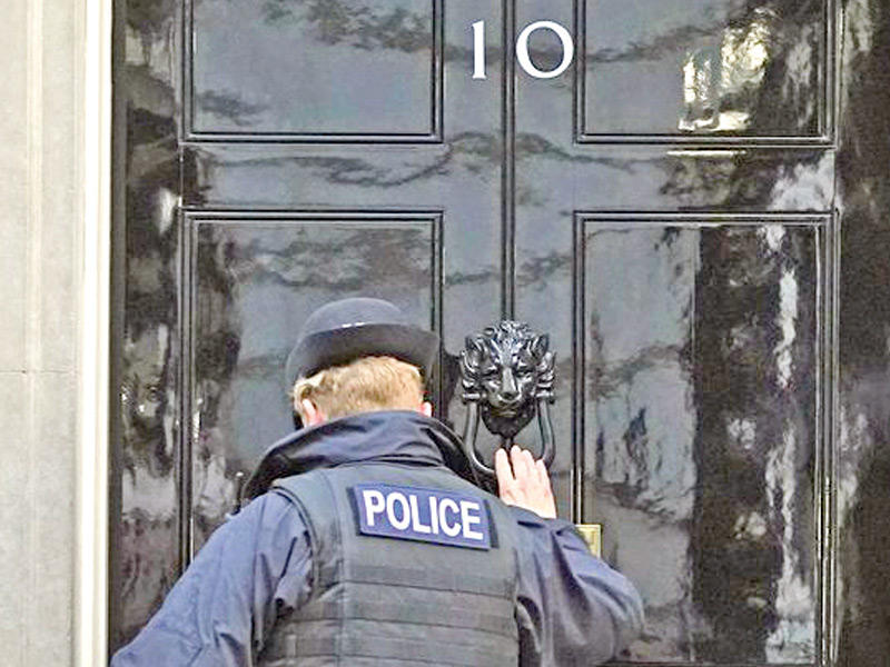 شرطة لندن تطرق باب احد المخالفين قواعد مكافحة فيروس كورونا وقت الإغلاق لتحرير الغرامة