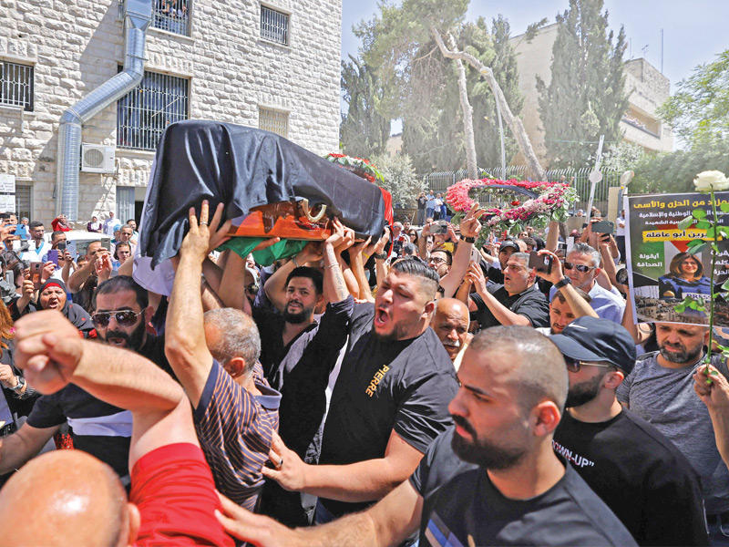 فلسطينيون يحملون نعش شيرين أبوعاقلة أمام منزلها في القدس (أ ف ب)
