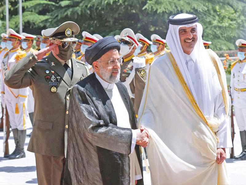 رئيسي مصافحاً تميم لدى وصوله إلى القصر الرئاسي في طهران أمس (رويترز)