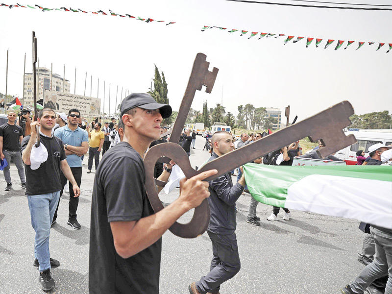 شبان فلسطينيون يحملون مفاتيح ضخمة ترمز إلى حق العودة خلال مسيرة في رام الله أمس tttttt       (أ ف ب)