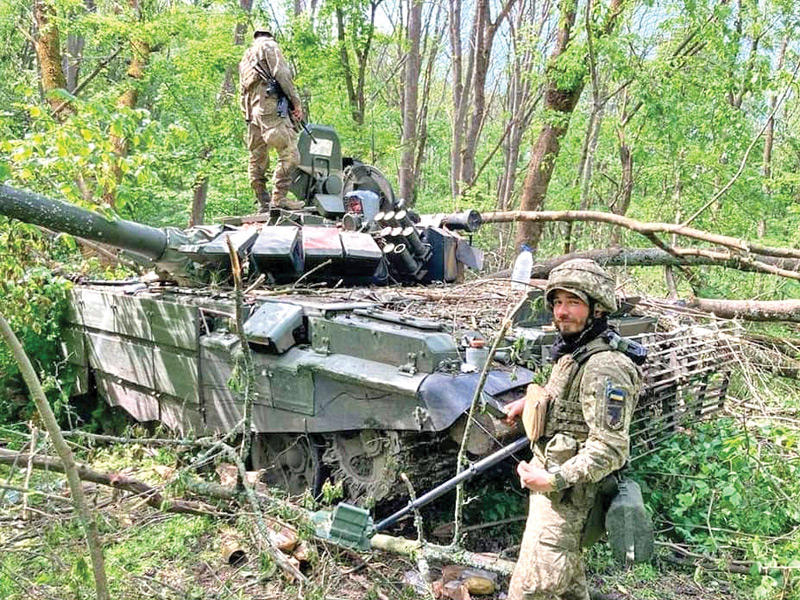 جنديان أوكرانيان يعاينان دبابة روسية مدمّرة أمس  (ا ف ب)