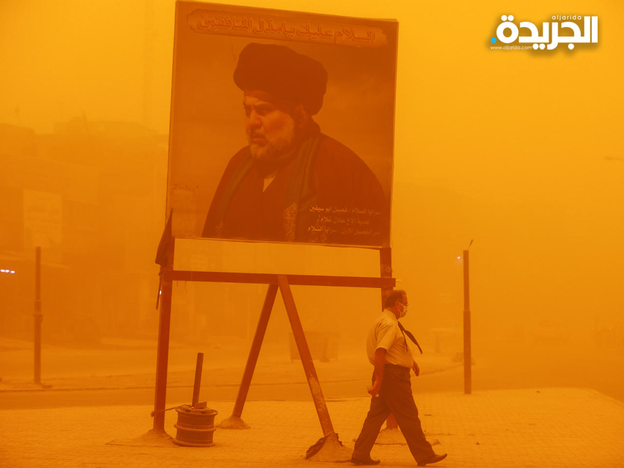 عراقي يمر من جانب صورة زعيم التيار الصدري مقتدى الصدر