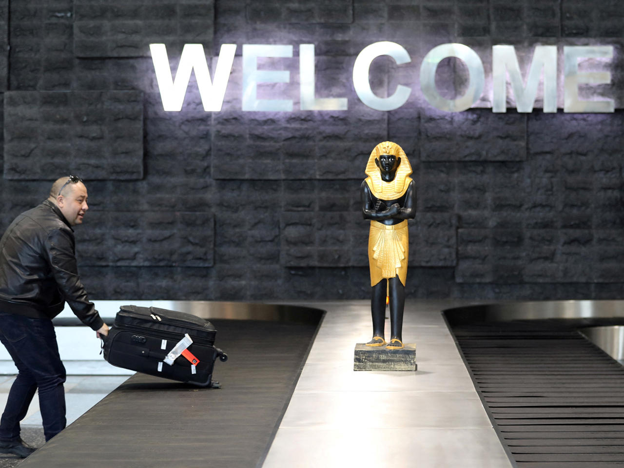 مسافر يتسلم الحقائب في مطار سفنكس