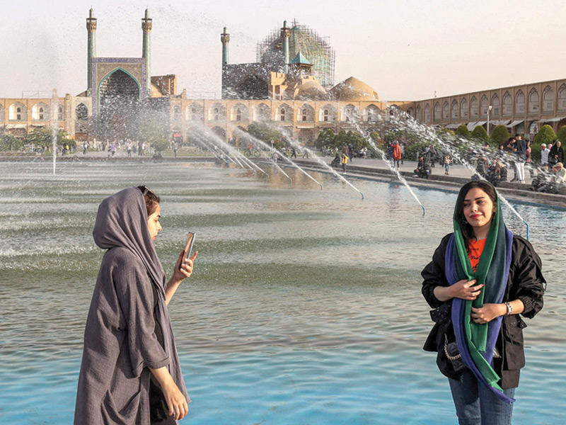 إيرانية تلتقط صورة في موقع نقش جهان الذي يعود إلى زمن الصفويين (أ ف ب)