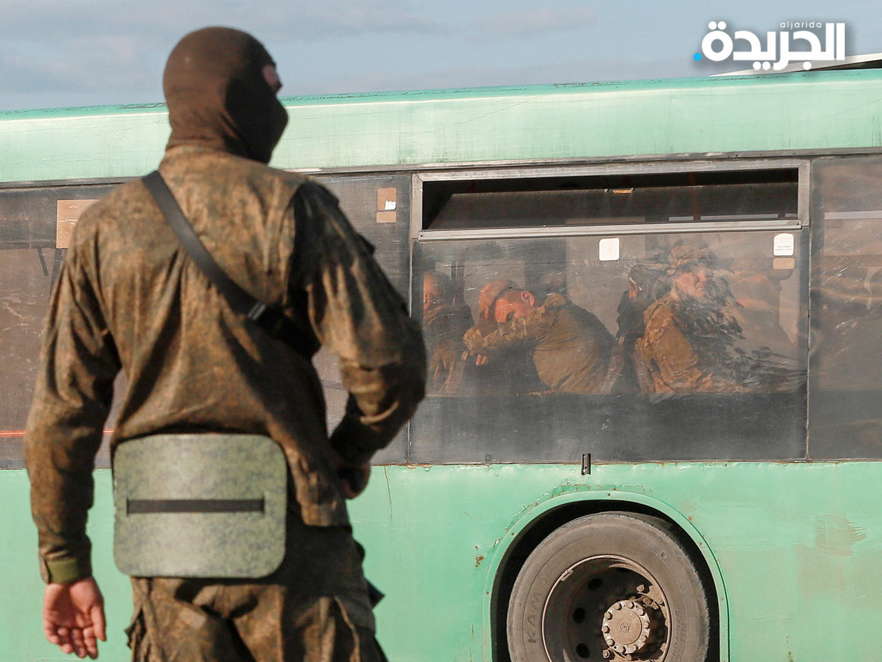 جندي روسي يقف في حراسة على طريق بالقرب من حافلة تقل جنوداً أوكرانيين استسلموا في مصنع آزوفستال المحاصر