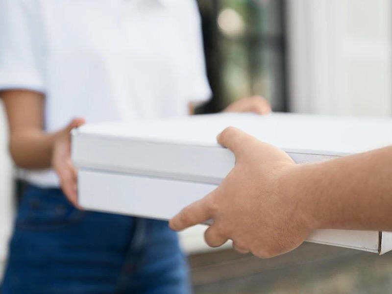 أحد عمال التوصيل يسلم الطلب