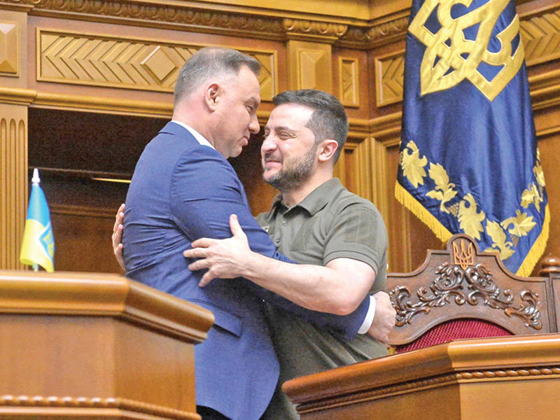 زيلينسكي معانقاً نظيره دودا في البرلمان بكييف (رويترز)