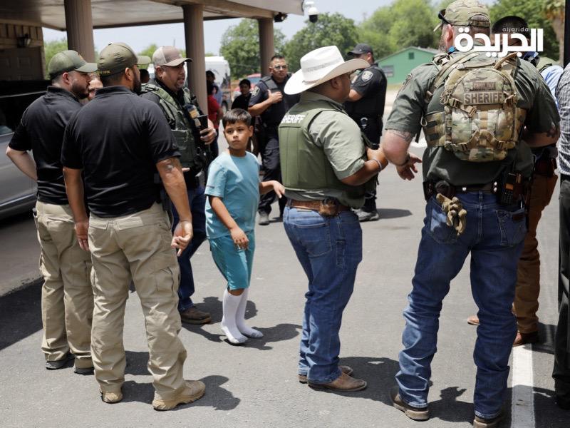 رجال الشرطة يخرجون الأطفال من موقع الجريمة