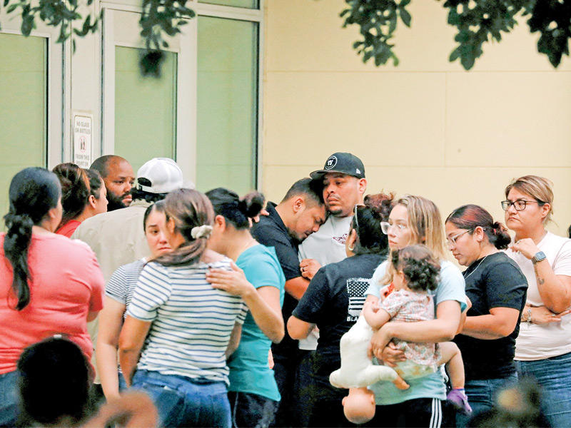 أهالي تلاميذ المدرسة المنكوبة خارج مستشفى نقل إليه ضحايا مجزرة تكساس أمس الأول (رويترز)