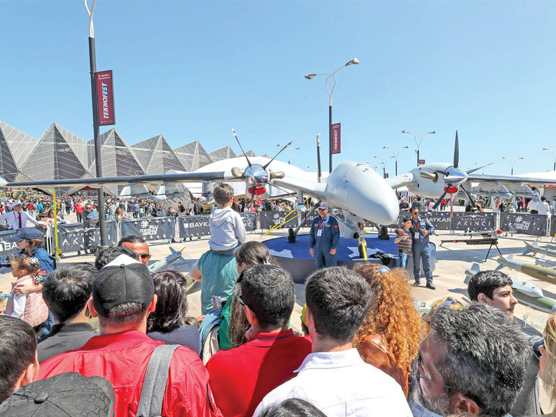 زوار يتحلقون حول «بيرقدار» في باكو (أ ف ب) 