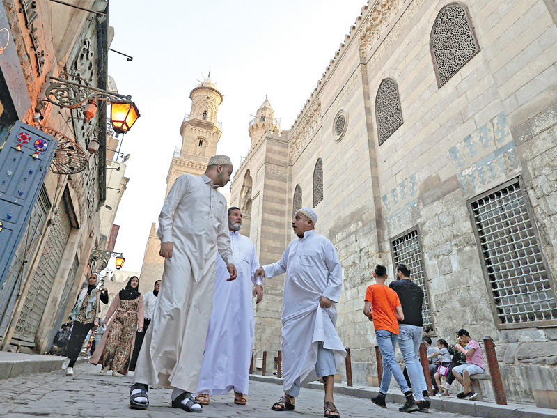 مصريون في شارع المعز بالقاهرة (رويترز)