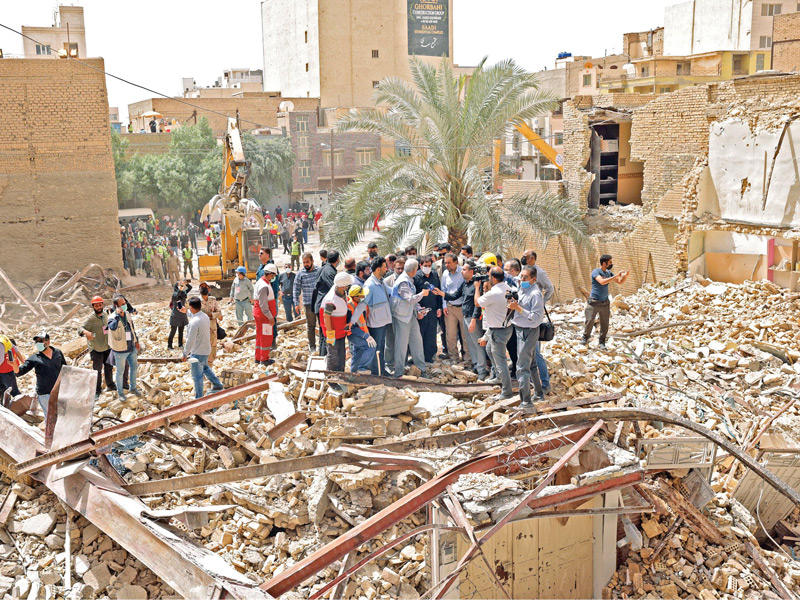 نائب رئيسي بين مواطنين إيرانيين خلال تفقده البرج المهدم في عبادان