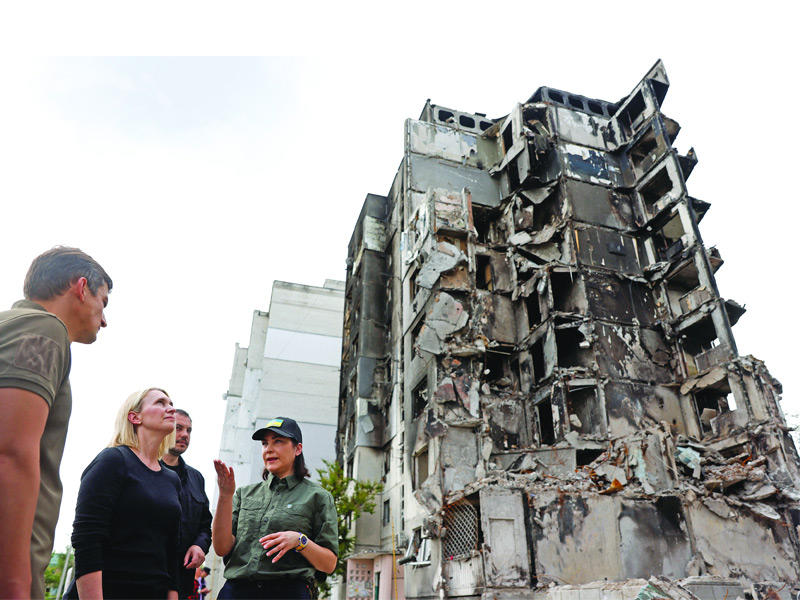 المدعية العامة الأوكرانية تتحدّث مع السفيرة الأميركية بريجيت برينك قرب مبنى مدمر خلال زيارة لبوروديانكا (رويترز)
