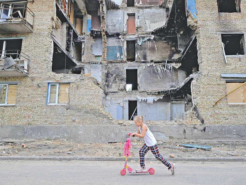 طفلة تلعب قرب مبنى مدمّر في قرية هورينكا في كييف (ا ف ب)