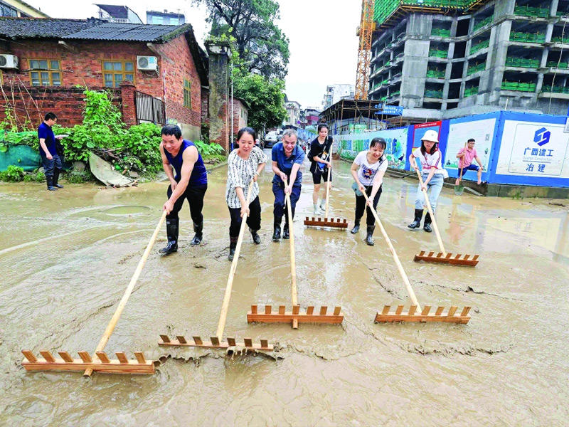صينيون يحاولون فتح طريق أغلقته السيول في منطقة رونغان الجنوبية     (أ ف ب)