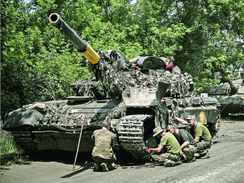 عناصر من القوات الأوكرانية يصلحون دبابة في منطقة دونباس (أ ف ب)