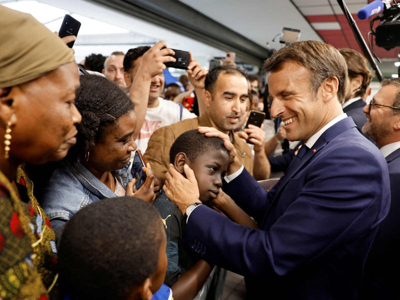 الرئيس الفرنسي إيمانويل ماكرون يحيي الناس خلال افتتاح دوجو (مكان للفنون القتالية) في مركز تسوق في الحي الشعبي