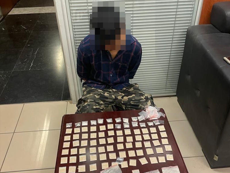 الآسيوي الموقوف وأمامه المخدرات