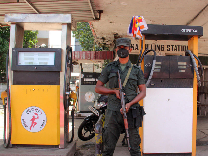 أحد أفراد الأمن السريلانكي يقف في حراسة مع نفاد البنزين من محطة وقود في كولومبو في 19 يونيو 2022 