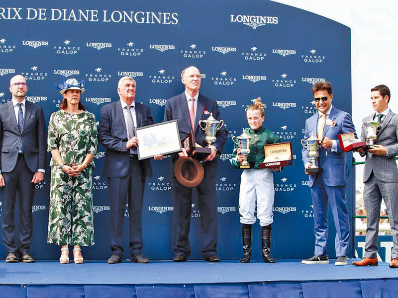 رجل الاعمال الكويتي عماد الصقر حاملاً كأس سباق «الأوكس» الفرنسي