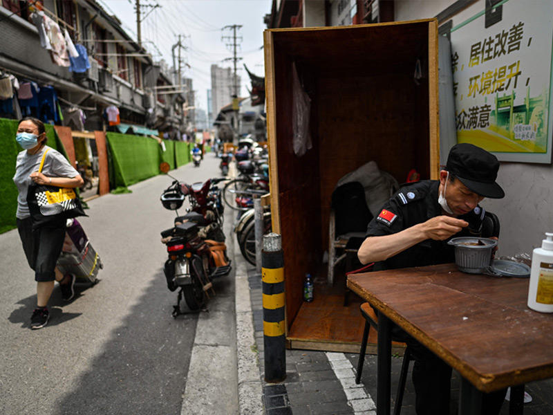ضابط شرطة صيني يتناول طعام الغداء في منطقة هوانغبو بشنغهاي (أ ف ب)