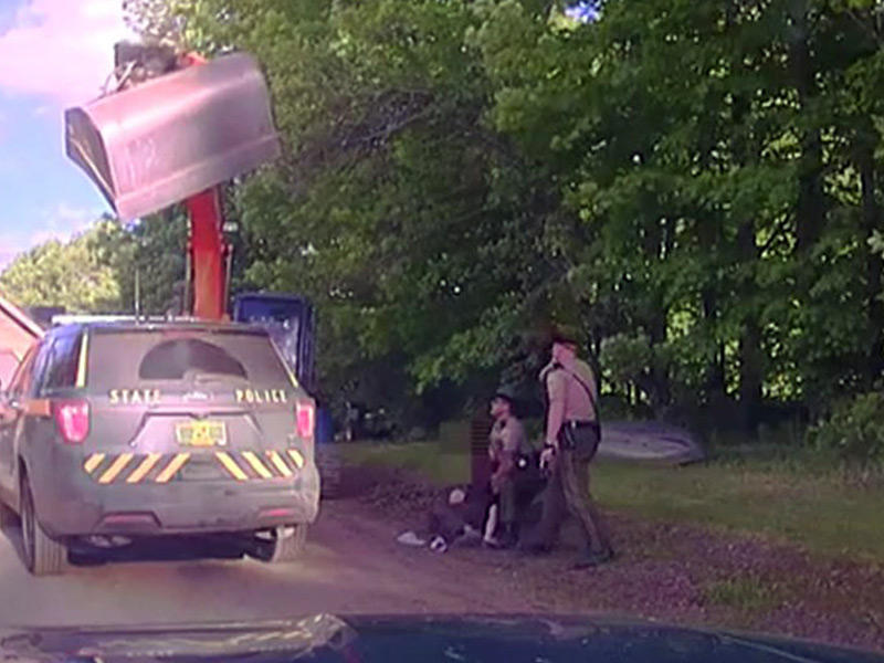 لقطة من الفيديو المتداول لرجل منع ضباط الشرطة من اعتقال ابنه باستخدام الجرافة