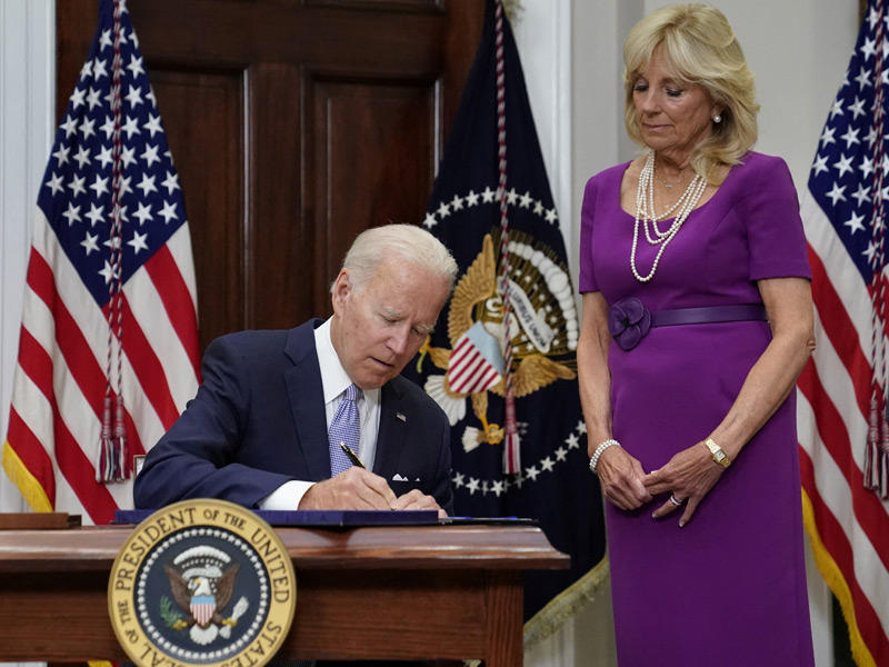 الرئيس جو بايدن يوقع قانون تنظيم السلاح بحضور زوجته جيل في غرفة روزفلت بالبيت الأبيض اليوم (رويترز)