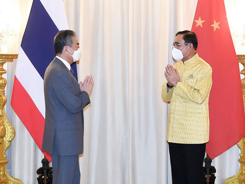 رئيس الوزراء التايلندي مستقبلاً ووانغ يي في بانكوك  (أ ف ب)