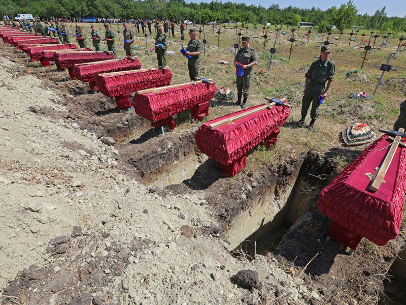 عسكريون خلال جنازة 58 جندياً مجهولي الهوية من جمهورية لوهانسك الشعبية (رويترز)