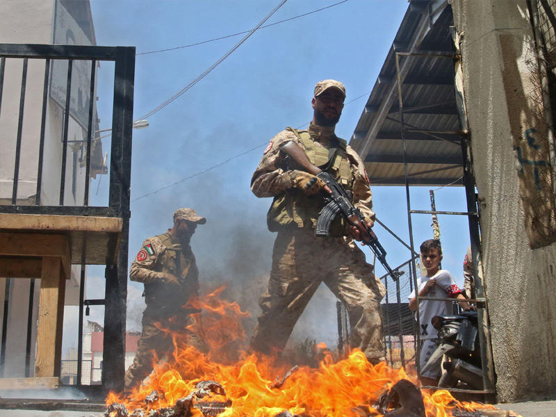 مسلحون فلسطينيون يتظاهرون ضد بايدن في مخيم عين الحلوة جنوب لبنان (أ ف ب)