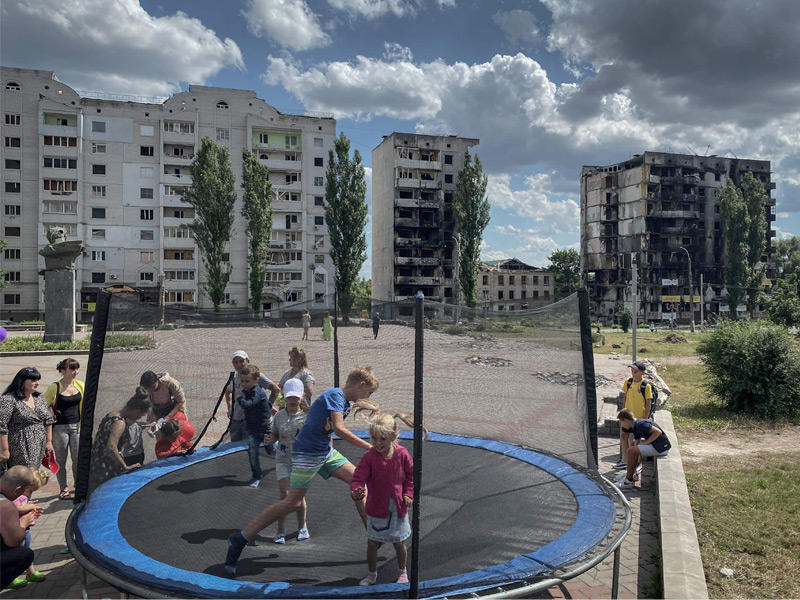 أطفال يلعبون قرب مبانٍ مدمرة في بوروديانكا شمال غرب كييفt (أ ف ب)