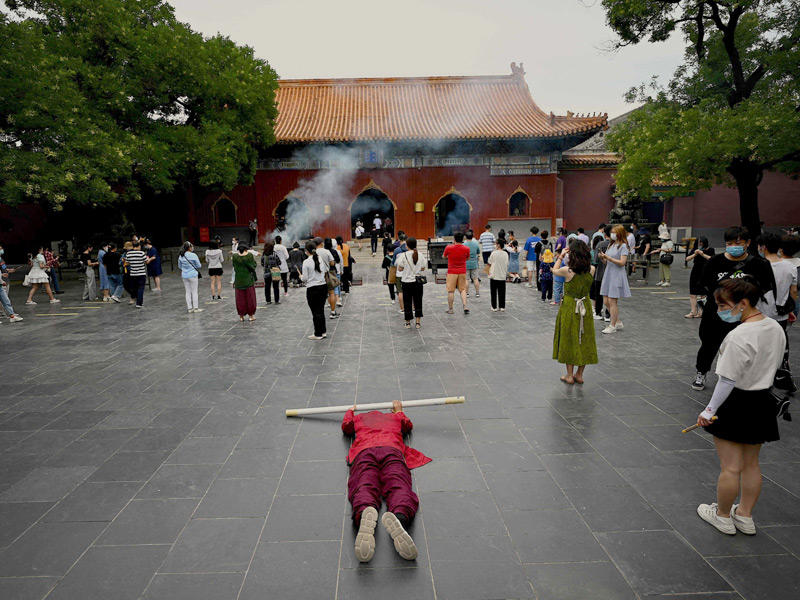 صينيون يؤدون طقوساً في باحة معبد يونغهي المعروف بـ «لاما» في بكين  (أ ف ب)