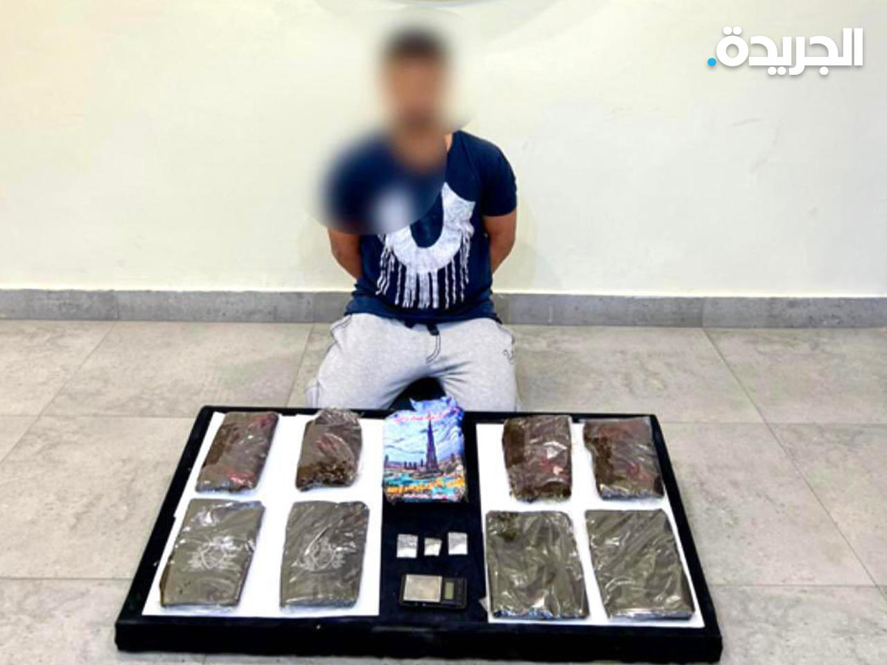 الشخص المضبوط وأمامه المواد المخدرة التي عثر عليها بحوزته