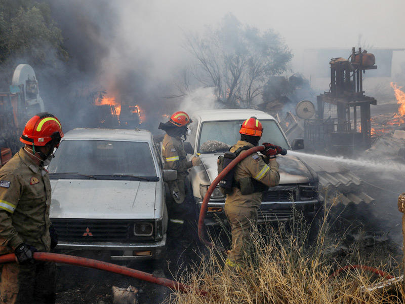 رجال الإطفاء يحاولون إخماد حريق هائل في باليني قرب أثينا أمس (رويترز)