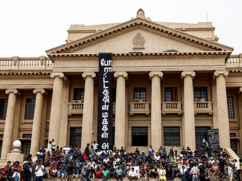 متظاهرون يتابعون تصويت البرلمان وسط كولومبو  (رويترز)