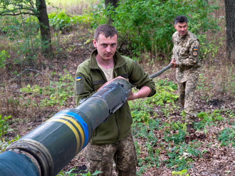 جنديان أوكرانيان ينظفان فوهة مدفع قرب خاركيف (أ ف ب)