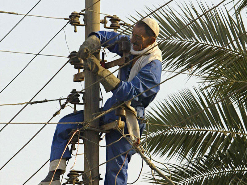 احد موظفي وزارة الكهرباء والماء اثناء الصيانة الدورية لاعمدة الكهرباء 