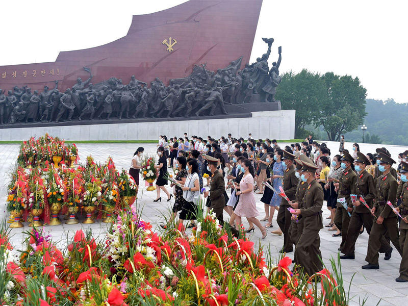 كوريون شماليون يضعون الزهور أمام تمثالَي كيم سونغ وكيم جونغ في بيونغيانغ أمس (أ ف ب)
