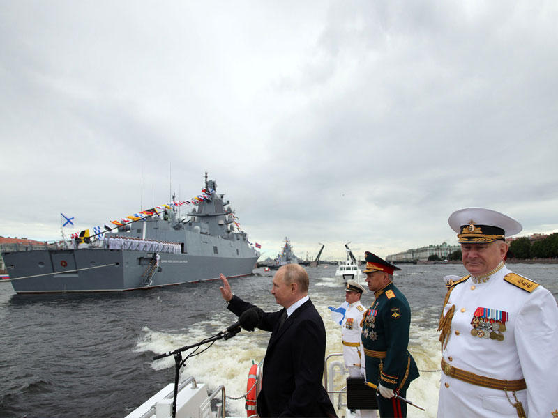 بوتين وخلفه شويغو ويفمينوف خلال مشاركتهم بـ «يوم الأسطول الحربي الروسي» في بطرسبورغ (أ ف ب)
