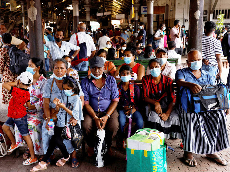 سريلانكيون بانتظار القطار في إحدى محطات كولومبو (رويترز)