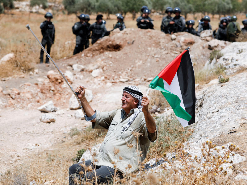 نابلسي مسن يتحدى قوات الاحتلال خلال احتجاجات على الاستيطان في بيت دجن (رويترز)