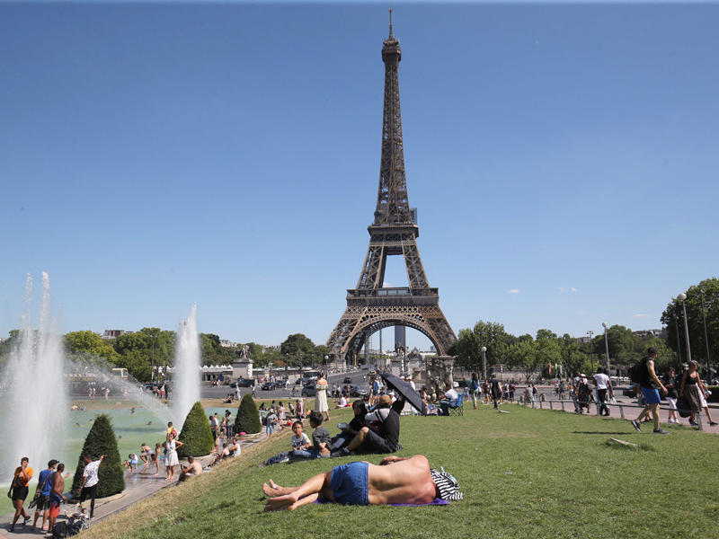 تجمهر الناس حول نافورة قرب برج ايفل بسبب الحر 